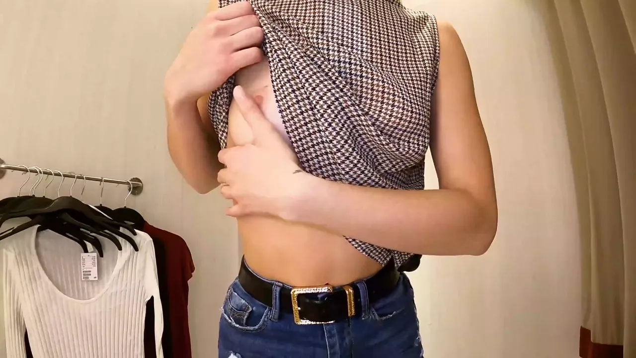 Slender girl Kelly Aleman tries on long sleeve shirts without a bra in the mall dressing
