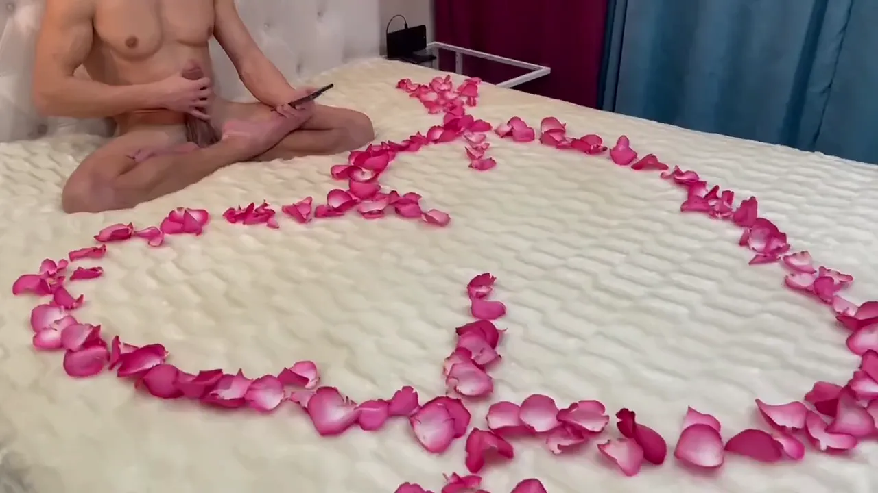 Young lad is waiting for his mature lady for romantic sex on a bed covered in rose petals